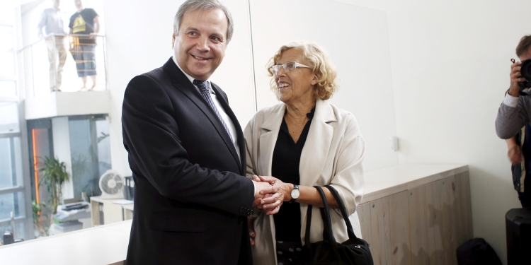 Ahora Madrid (Now Madrid) local candidate Manuela Carmena (C) and Socialist Party (PSOE) local candidate Antonio Miguel Carmona (L) hold hands as they pose at the start of a news conference in Madrid, Spain, June 12, 2015. Manuela Carmena, 71, cut a deal with the opposition Socialists to form a coalition administration. The left-wing former judge, backed by anti-austerity party Podemos, was named mayor of Spain's capital on Friday, ending 24 years of centre-right Popular Party (PP) rule in Madrid and delivering a setback to Prime Minister Mariano Rajoy. REUTERS/Susana Vera - RTX1G7QP