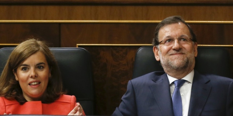 Spain's Prime Minister Mariano Rajoy (R) reacts, next to Deputy Prime Minister Soraya Saenz de Santamaria, to applause by party members after answering a question during a government control session at Spain's Parliament in Madrid, Spain, June 17, 2015. REUTERS/Andrea Comas - RTX1GUOM