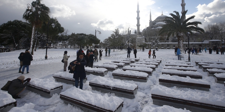Tourists take a photo on the snow-covered Sultanahmet Square in the historic old town of Istanbul, Turkey,  December 31, 2015.  REUTERS/Osman Orsal - RTX20MLP