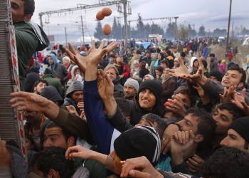 Migrants try to get products from a truck at a makeshift camp on the Greek-Macedonian border near the village of Idomeni, Greece March 10, 2016.    REUTERS/Stoyan Nenov TPX IMAGES OF THE DAY - RTSA7VY