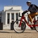 A cyclist passes the Federal Reserve headquarters in Washington September 16, 2015. The Federal Reserve, facing this week its biggest policy decision yet under Chair Janet Yellen, puts its credibility on the line regardless of whether it waits or raises interest rates for the first time in nearly a decade.       REUTERS/Kevin Lamarque  - RTS1E8N