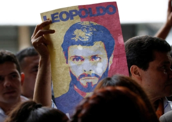 A supporter of jailed Venezuelan opposition leader Leopoldo Lopez holds a poster depicting him outside the courthouse in Caracas, Venezuela June 20, 2016. REUTERS/Carlos Garcia Rawlins - RTX2H7IN