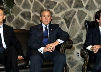 British Prime Minister Tony Blair (L), U.S. President George W. Bush (C) and Spanish Prime Minister Jose Maria Aznar meet at Lajes Field in the Azores, March 16, 2003. [The meeting was portrayed as a final diplomatic push for a U.N. resolution demanding that Iraq disarm or face attack. Bush said on Sunday he believed the United Nations must have a role in rebuilding Iraq after the removal of President Saddam Hussein.] - RTXLUER