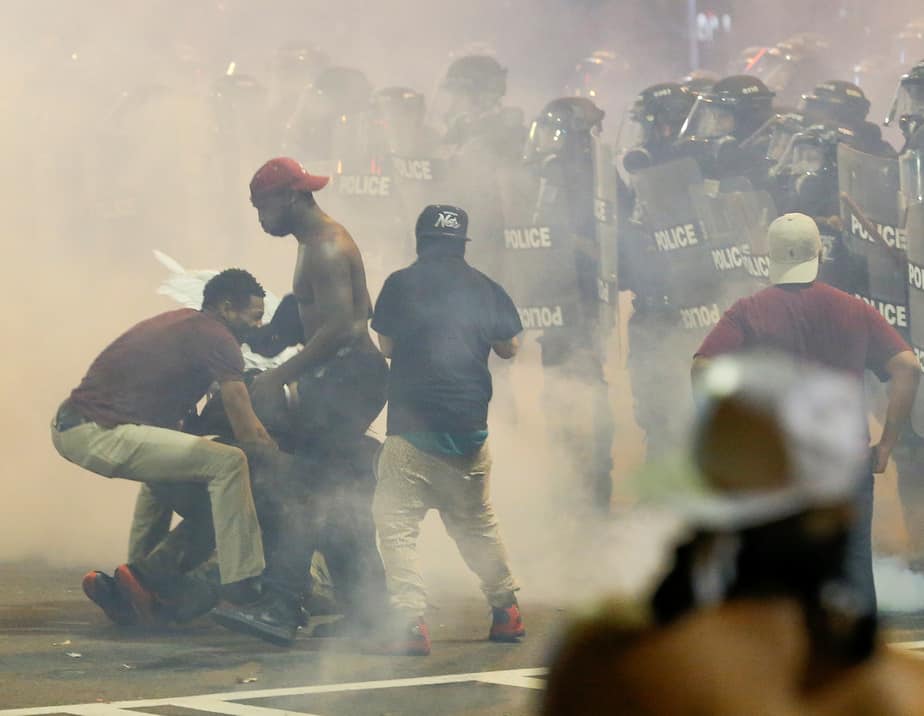 People maneuver amongst tear gas in uptown Charlotte, NC during a protest of the police shooting of Keith Scott, in Charlotte, North Carolina, U.S. September 21, 2016. REUTERS/Jason Miczek     TPX IMAGES OF THE DAY      - RTSOVKR
