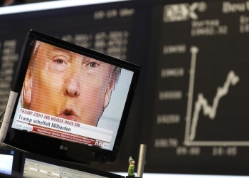 A TV screen showing U.S. President-elect Donald Trump is pictured in front of the German share price index, DAX board, at the stock exchange in Frankfurt, Germany, November 9, 2016. REUTERS/Staff/Remote - RTX2SQVH