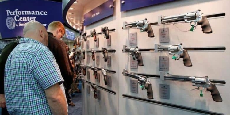 Gun enthusiasts look over Smith & Wesson guns at the National Rifle Association's (NRA) annual meetings and exhibits show in Louisville, Kentucky, May 21, 2016.   REUTERS/John Sommers II/File Photo