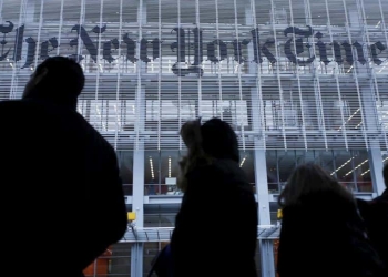 People stand across the street from the New York Times head office in New York, in this February 7, 2013, file photo.   REUTERS/Carlo Allegri/Files