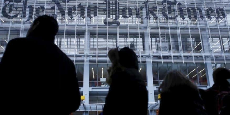 People stand across the street from the New York Times head office in New York, in this February 7, 2013, file photo.   REUTERS/Carlo Allegri/Files