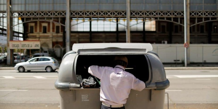 Un hombre buscando en la basura en Sevilla. FOTO: Reuters