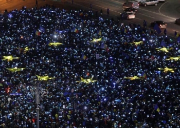 Romanians light up blue pieces of paper and pieces of yellow star shaped fabric thus forming the European Union flag during a protest against the government, in Bucharest, Romania, February 26, 2017. Inquam Photos/Octav Ganea/via REUTERS