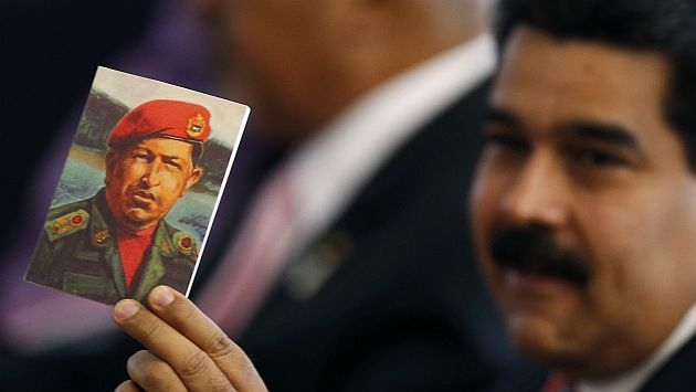Venezuela's President Nicolas Maduro holds a photo of former Venezuelan President Hugo Chavez during the meeting of China and CELAC at Itamaraty Palace in Brasilia July 17, 2014. Brazil hosted the meeting of China and Community of Latin American and Caribbean States (CELAC). REUTERS/Ueslei Marcelino (BRAZIL - Tags: POLITICS)