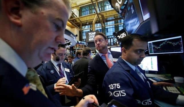 Traders work on the floor of the New York Stock Exchange (NYSE) as the Dow Jones Industrial Average passes the 20,000 mark shortly after the opening of the trading session in New York, U.S., January 25, 2017. REUTERS/Brendan McDermid