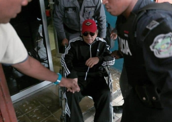 Former Panamanian dictator Manuel Noriega sits in a wheelchair as prison wardens help him after a health check up at the facilities of the Public Ministry in Panama City, Panama, July 22, 2016. REUTERS/Alberto Solis/Files