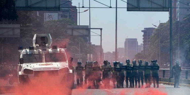 Riot police clash with demonstrators protesting against President Nicolas Maduro's government in Caracas on April 8, 2017. 
The opposition is accusing pro-Maduro Supreme Court judges of attempting an internal "coup d'etat" for attempting to take over the opposition-majority legislature's powers last week. The socialist president's supporters held counter-demonstrations on Thursday, condemning Maduro's opponents as "imperialists" plotting with the United States to oust him.
 / AFP PHOTO / FEDERICO PARRA