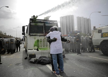 Abrazo entre un manifestante y un policía en Caracas, Venezuela. FOTO: Reuters