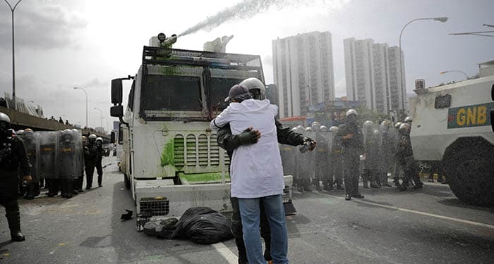 Abrazo entre un manifestante y un policía en Caracas, Venezuela. FOTO: Reuters