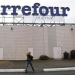 A woman walks below the logo of Carrefour Planet supermarket in Bordeaux, southwestern France, January 19, 2012. REUTERS/Regis Duvignau