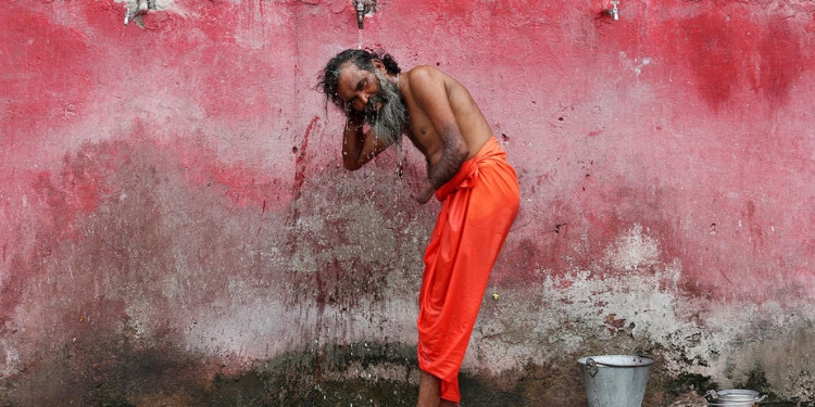 Un sadhu o un hombre santo hindú se baña antes de registrarse para la peregrinación anual al santuario de la cueva de Amarnath, en un campamento base en Jammu