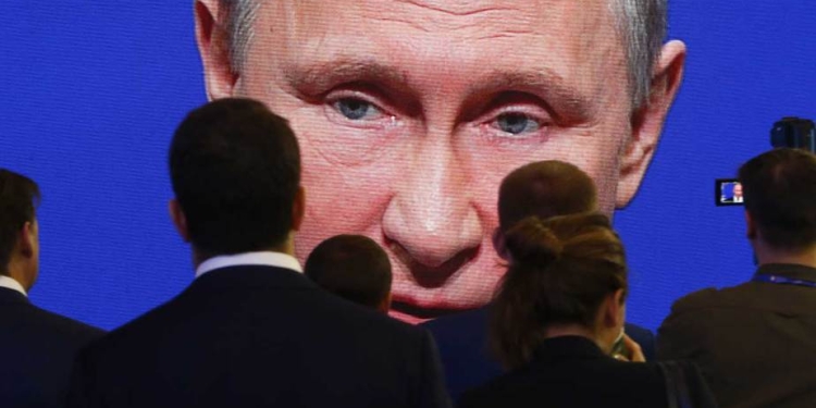 Los participantes del  Foro Económico Internacional de San Petersburgo (SPIEF) se reúnen cerca de una pantalla electrónica que muestra al presidente Vladimir Putin, quien interviene en una de las sesiones (02/06/2017) Reuters