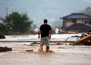 Un residente local camina en una zona dañada por un río hinchado después de una fuerte lluvia en Asakura, Prefectura de Fukuoka, Japón