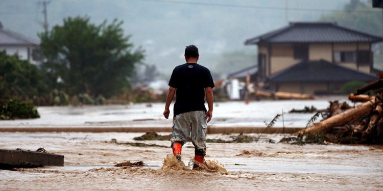 Un residente local camina en una zona dañada por un río hinchado después de una fuerte lluvia en Asakura, Prefectura de Fukuoka, Japón