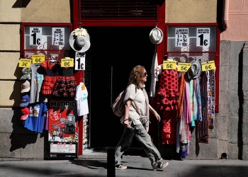 Una mujer pasa por delante de un comercio en Madrid.