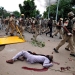 Las fuerzas de seguridad marchan por delante del cuerpo de un hombre muerto durante la violencia en Panchkula, India