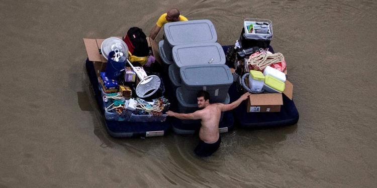 Residents wade with their belongings through flood waters brought by Tropical Storm Harvey in Northwest Houston, Texas, U.S. August 30, 2017. Picture taken August 30, 2017. REUTERS/Adrees Latif     TPX IMAGES OF THE DAY