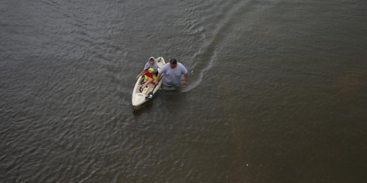 Jesús Rodríguez rescata a Gloria García después de que la lluvia inundó Pearland, en las afueras de Houston, Texas. REUTERS / Adrees Latif
