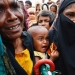 Un bebé refugiado rohingya llora mientras su madre se apresura a pedir ayuda en Cox's Bazar, Bangladesh