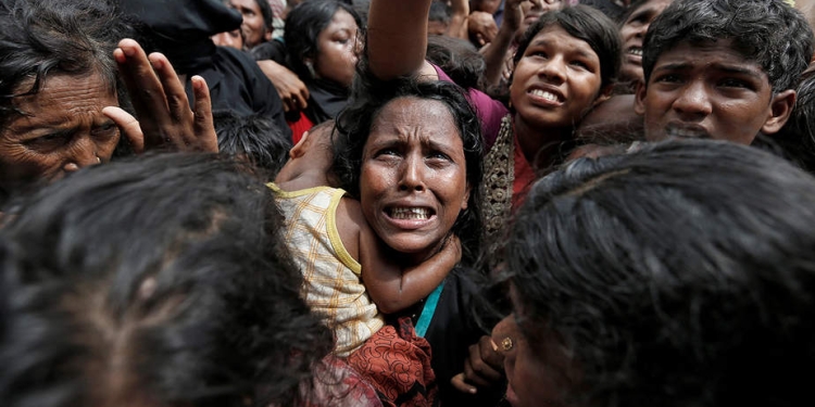 Una mujer reacciona mientras los refugiados rohingyas esperan para recibir ayuda en Cox's Bazar, Bangladesh