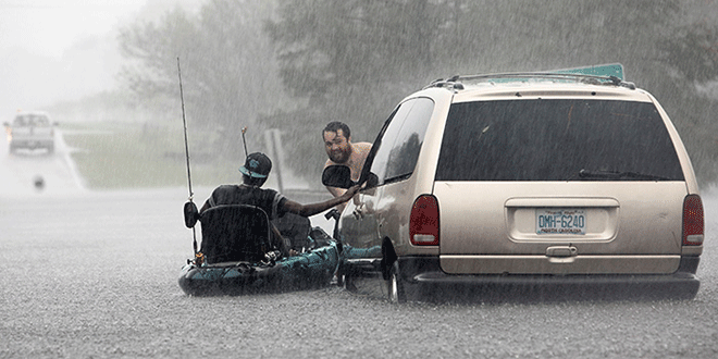 Jordan McKeon empuja mientras su amigo Nathaniel Harrison se aferra a su kayak. EE. UU. , 2018. REUTERS / Jonathan Drake