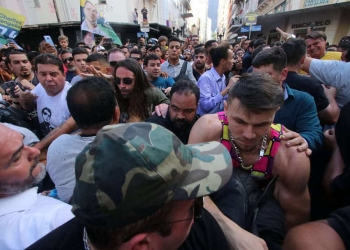 La gente rodea a un hombre sospechoso (no en la foto) de apuñalar al candidato presidencial brasileño Jair Bolsonaro (arriba a la derecha en amarillo) mientras este hacía campaña en Juiz de Fora, Brasil el 6 de septiembre de 2018. Felipe Couri / Minas Tribune / vía REUTERS