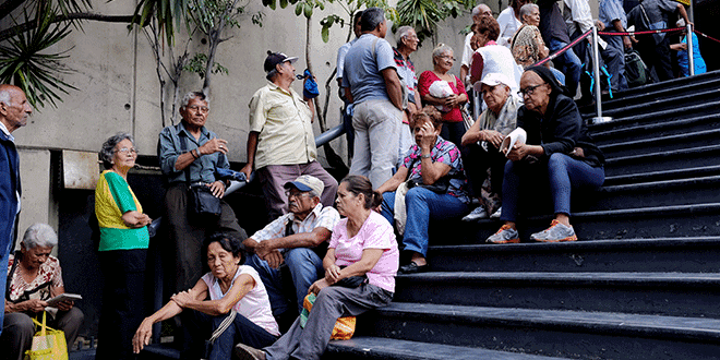 En la imagen, una grupo de personas aguarda su turno en un banco de Caracas para cobrar su pensión el 14 de septiembre de 2018. REUTERS/Marco Bello