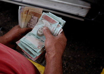 Un trabajador de una gasolinera de PDVSA cuenta bolívares en Caracas, sep 24, 2018. REUTERS/Marco Bello