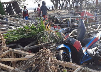 Varias personas pasean entre las ruinas de un puesto en la playa después de que el tsunami pasase por Palu, en la isla indonesia de Sulawesi el 29 de septiembre/Reuters