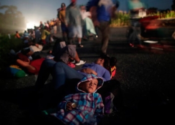 Glenda Escobar, parte de una caravana de miles de centroamericanos en camino a Estados Unidos, descansa en la carretera con su hijo Adonai, mientras se dirigen a Pijijiapan desde Mapastepec. 25 de octubre de 2018. REUTERS/Ueslei Marcelino