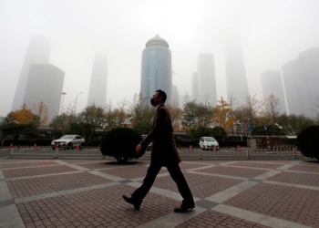 Un hombre camina con una mascarilla por el distrito empresarial del centro de Beijing, China, el 14 de noviembre de 2018. REUTERS/Jason Lee