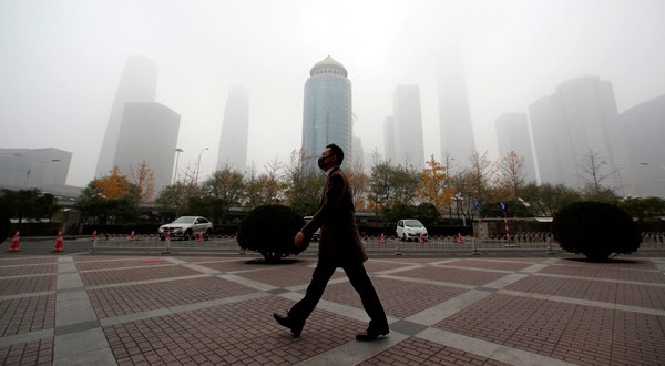 Un hombre camina con una mascarilla por el distrito empresarial del centro de Beijing, China, el 14 de noviembre de 2018. REUTERS/Jason Lee