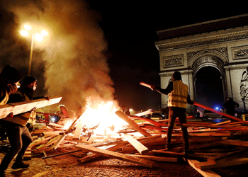 Manifestantes prenden fuego durante las protestas del "chaleco amarillo" contra los mayores precios del combustible en los Campos Elíseos en París, Francia, el 24 de noviembre de 2018. REUTERS / Benoit Tessier