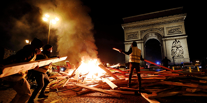 Manifestantes prenden fuego durante las protestas del "chaleco amarillo" contra los mayores precios del combustible en los Campos Elíseos en París, Francia, el 24 de noviembre de 2018. REUTERS / Benoit Tessier