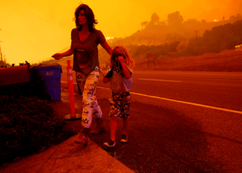Gabi y Jonah Frank caminan por la autopista de la costa del Pacífico mientras el incendio de Woolsey amenaza su hogar en Malibu, California, el 9 de noviembre de 2018. REUTERS / Eric Thayer