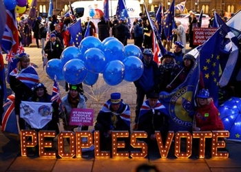 Manifestantes contra el Brexit  junto a un cartel iluminado en el entorno del Parlamento en Londres, Reino Unido, 10 de diciembre de 2018. REUTERS / Henry Nicholls