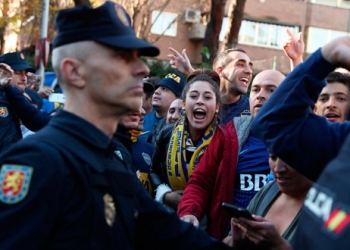 En la imagen, seguidores del Boca Juniors rodeados de policías en las puertas del hotel en el que se aloja el equipo en Madrid el 8 de diciembre de 2018. REUTERS/Susana Vera