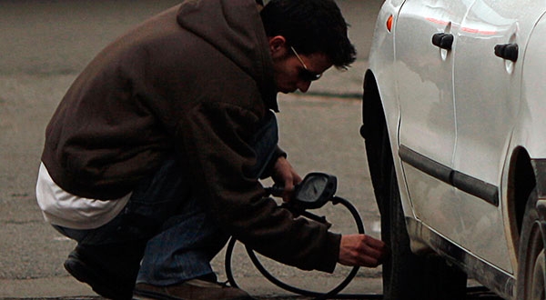 Un hombre infla un neumático. El IPC español sigue moderándose ante la baja de precios de los carburantes / REUTERS/Jon Nazca
