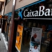 En la imagen de archivo, un hombre camina junto a una sucursal de Caixabank en Barcelona, España. REUTERS/Yves Herman