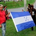 Personas sostienen una bandera de Honduras mientras esperan salir con una nueva caravana de migrantes, que se dirigirá a Estados Unidos, en una estación de autobuses en San Pedro Sula, Honduras, 14 de enero del 2019. REUTERS/Jorge Cabrera