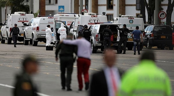 Policías y personal de seguridad en la academia policial donde explotó el coche bomba en Bogotá. REUTERS/Luisa González