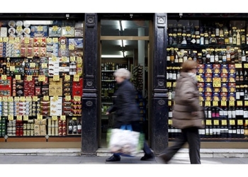 El INE reportó que los precios de consumo en España se mantuvieron moderados al final de 2018. Viandantes pasan frente a una tienda en Barcelona / REUTERS/Albert Gea