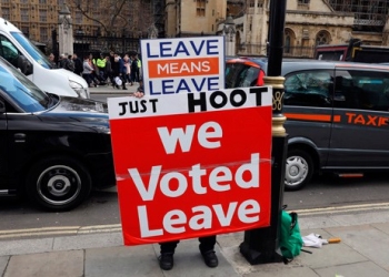 Un manifestante a favor del Brexit muestra una pancarta en la que se puede leer "Votamos salir" en las afueras del parlamento británico en Westminster.